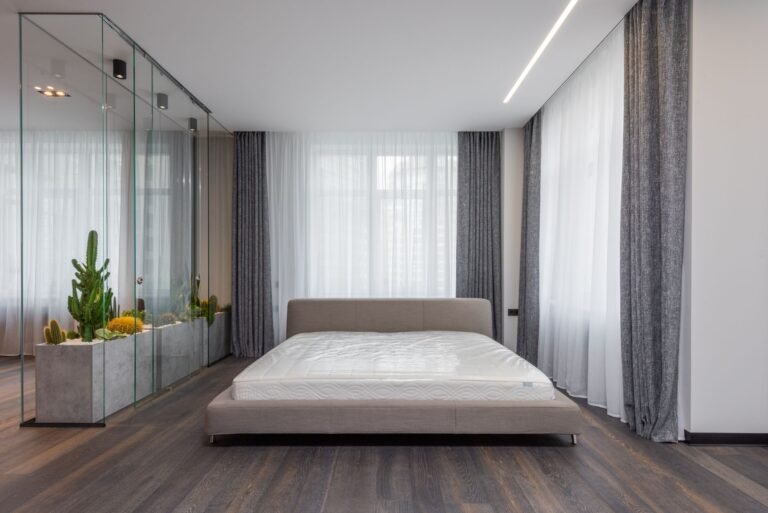 tijk voor waterbed — Interior of modern bedroom with comfortable bed and glasshouse with green plants which carrying out function of wall between areas in apartment