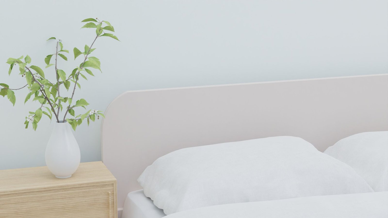 slaapsysteem — Soft and serene bedroom featuring white bedding and a vase with greenery on a wooden nightstand.